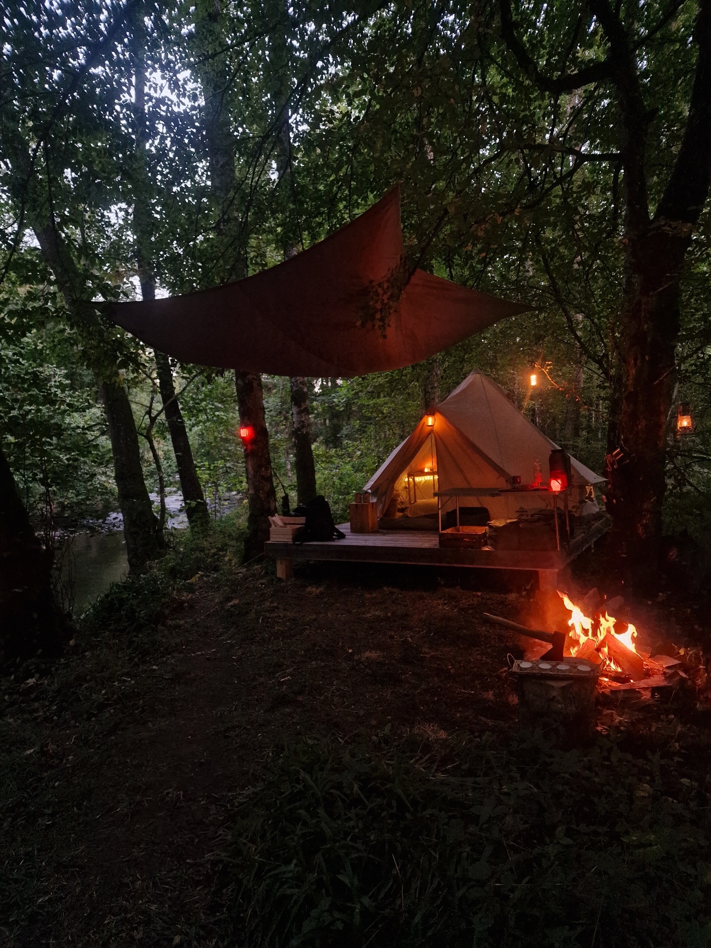 Glampingtent met kampvuur tussen de bomen in de Ardennen